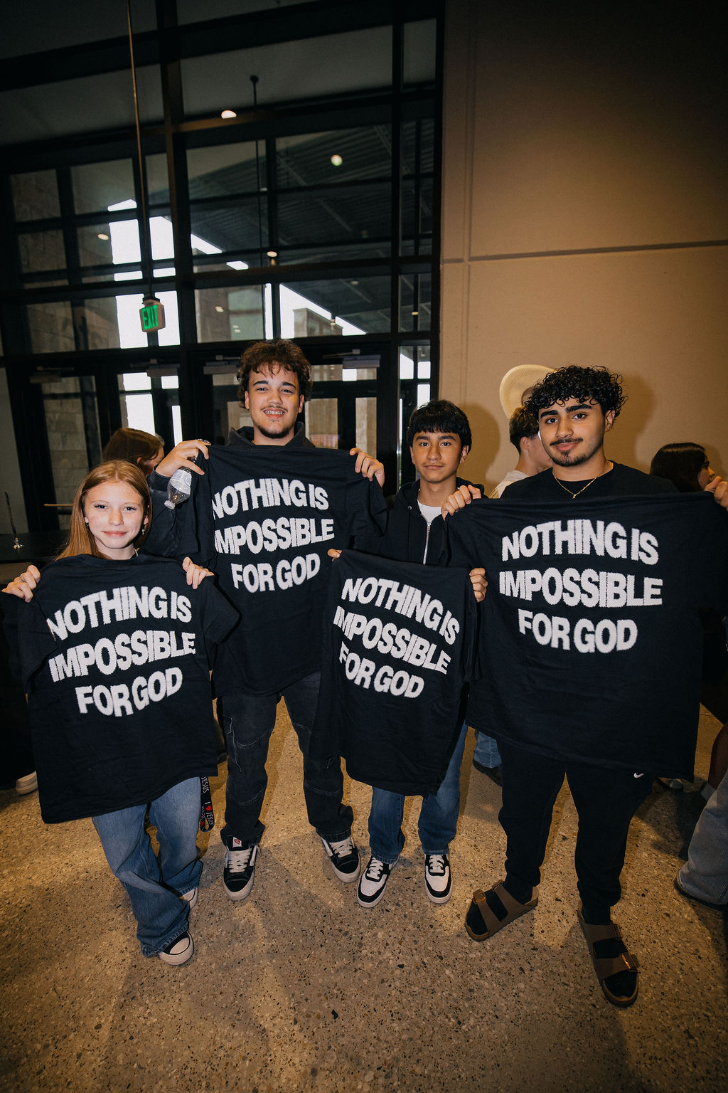 Students holding Nothing Is Impossible For God shirts at Elevate